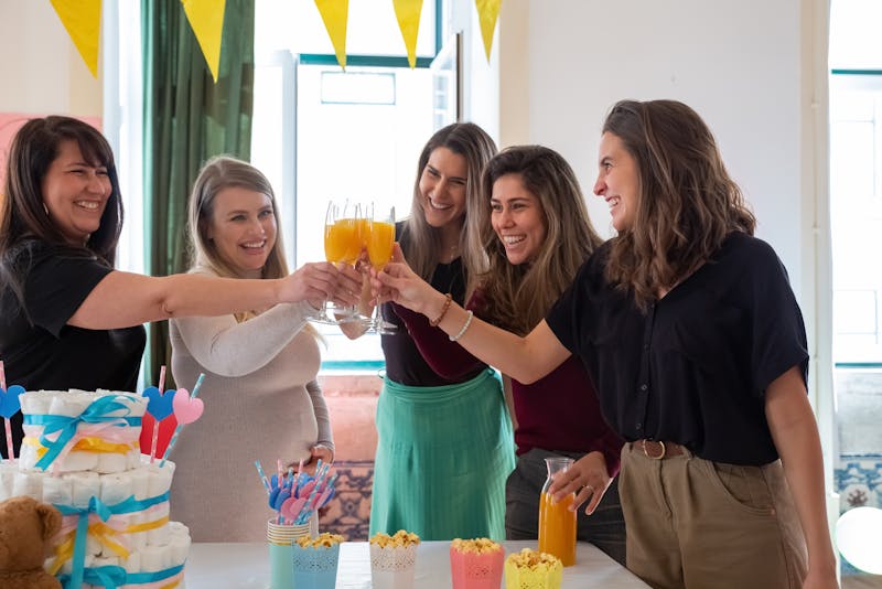 Women toasting at a baby shower celebration with a pregnant guest